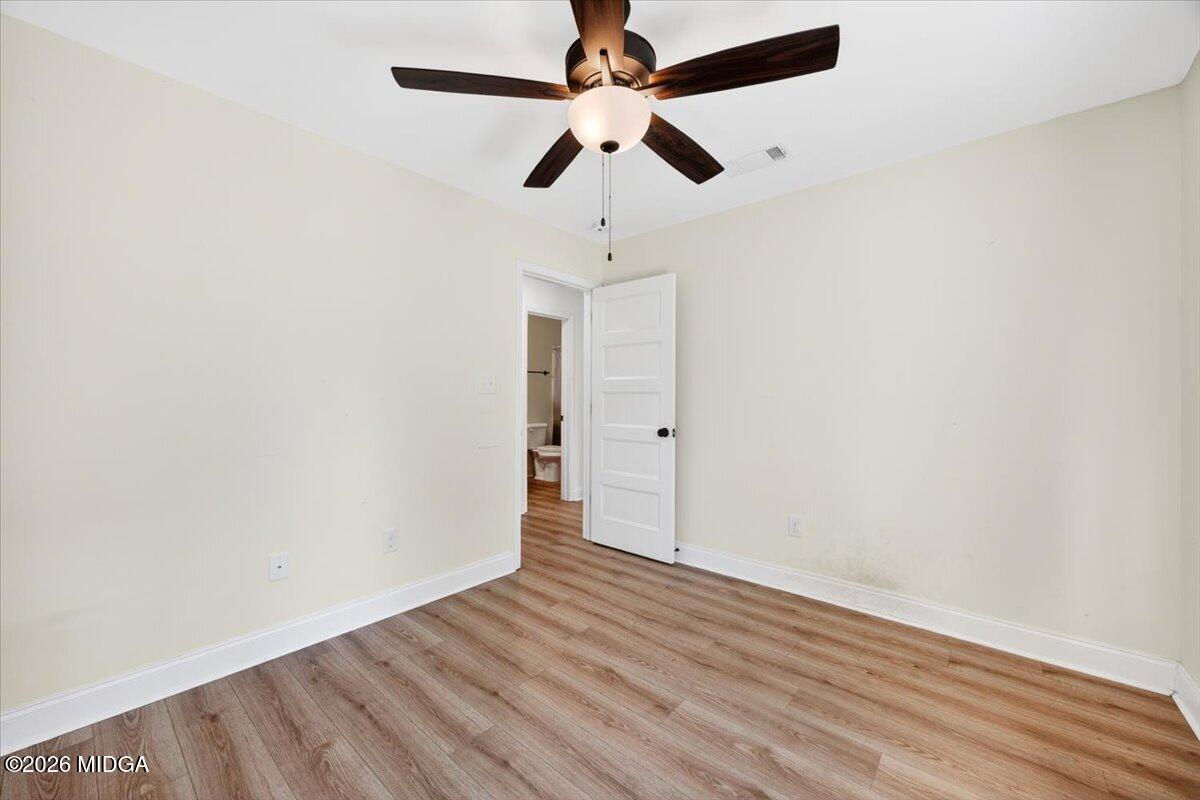 845 Natures Walk Gray, GA 31032 - Photo 17 of 21 an empty room with wooden floor ceiling fan and window