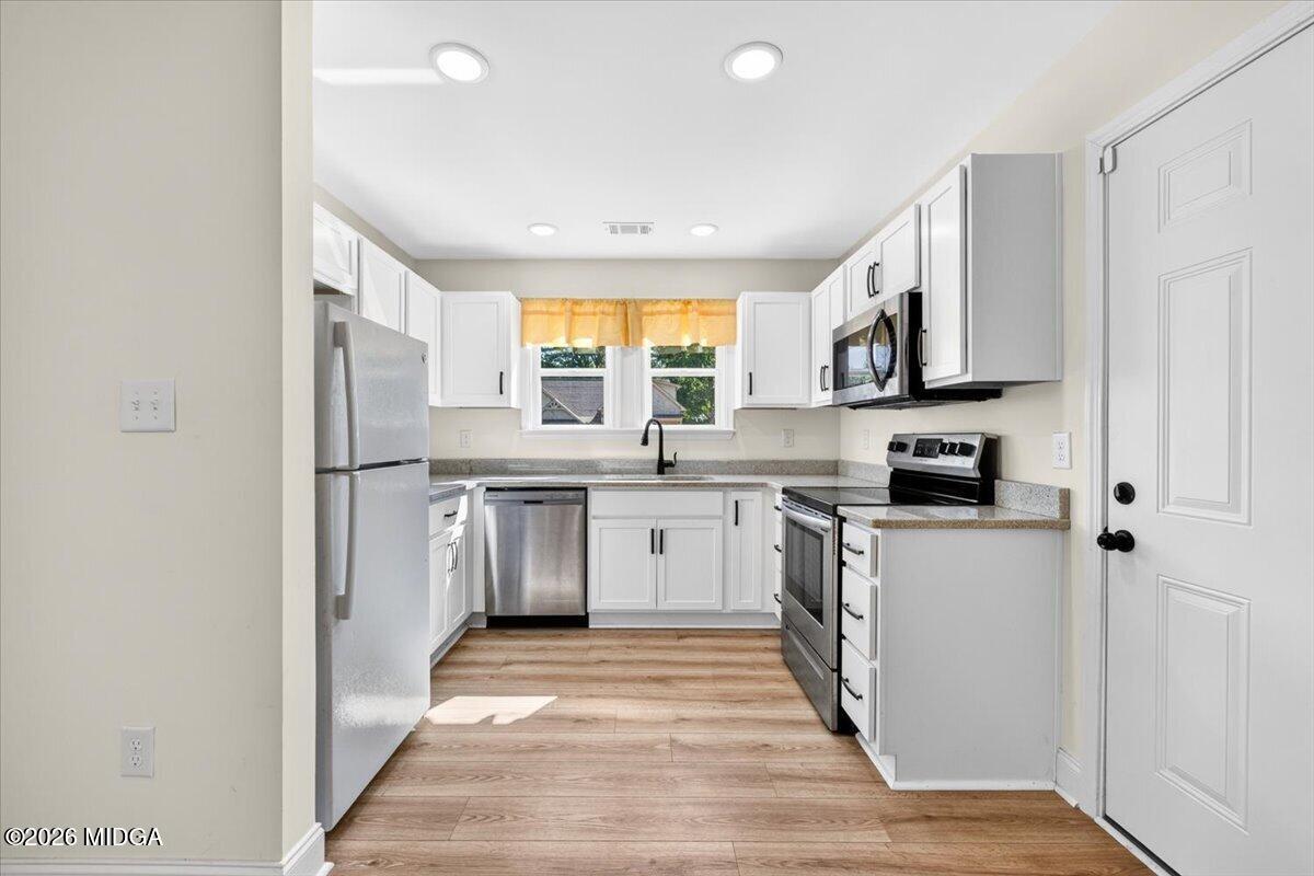 845 Natures Walk Gray, GA 31032 - Photo 7 of 21 a kitchen with stainless steel appliances granite countertop a refrigerator sink and wooden cabinets