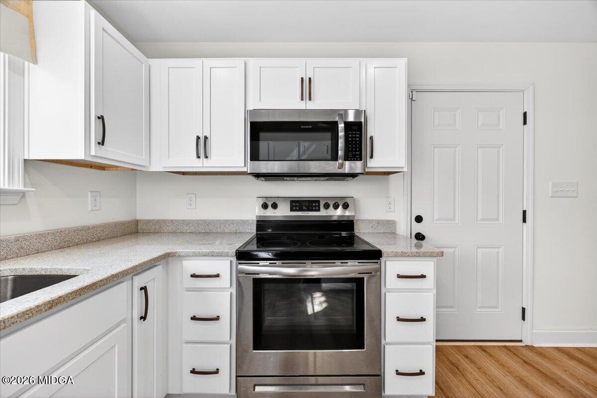 845 Natures Walk Gray, GA 31032 - Photo 8 of 21 a kitchen with granite countertop a stove top oven microwave and cabinets