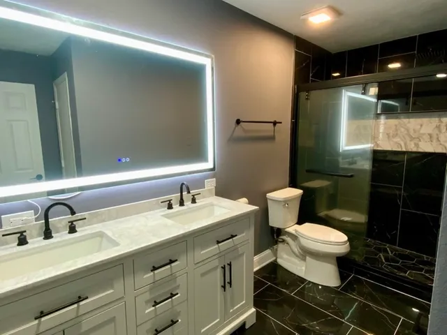 a bathroom with a double vanity sink mirror and toilet