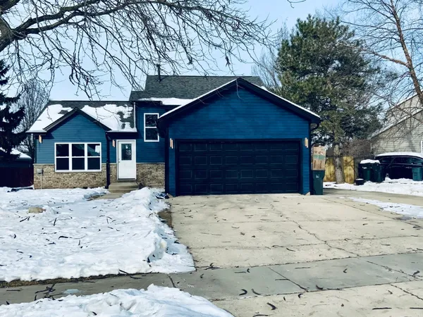 a front view of a house with a yard covered in snow