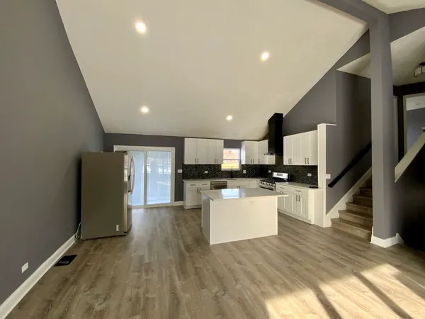 a kitchen with stainless steel appliances granite countertop a refrigerator a stove top oven a sink and dishwasher