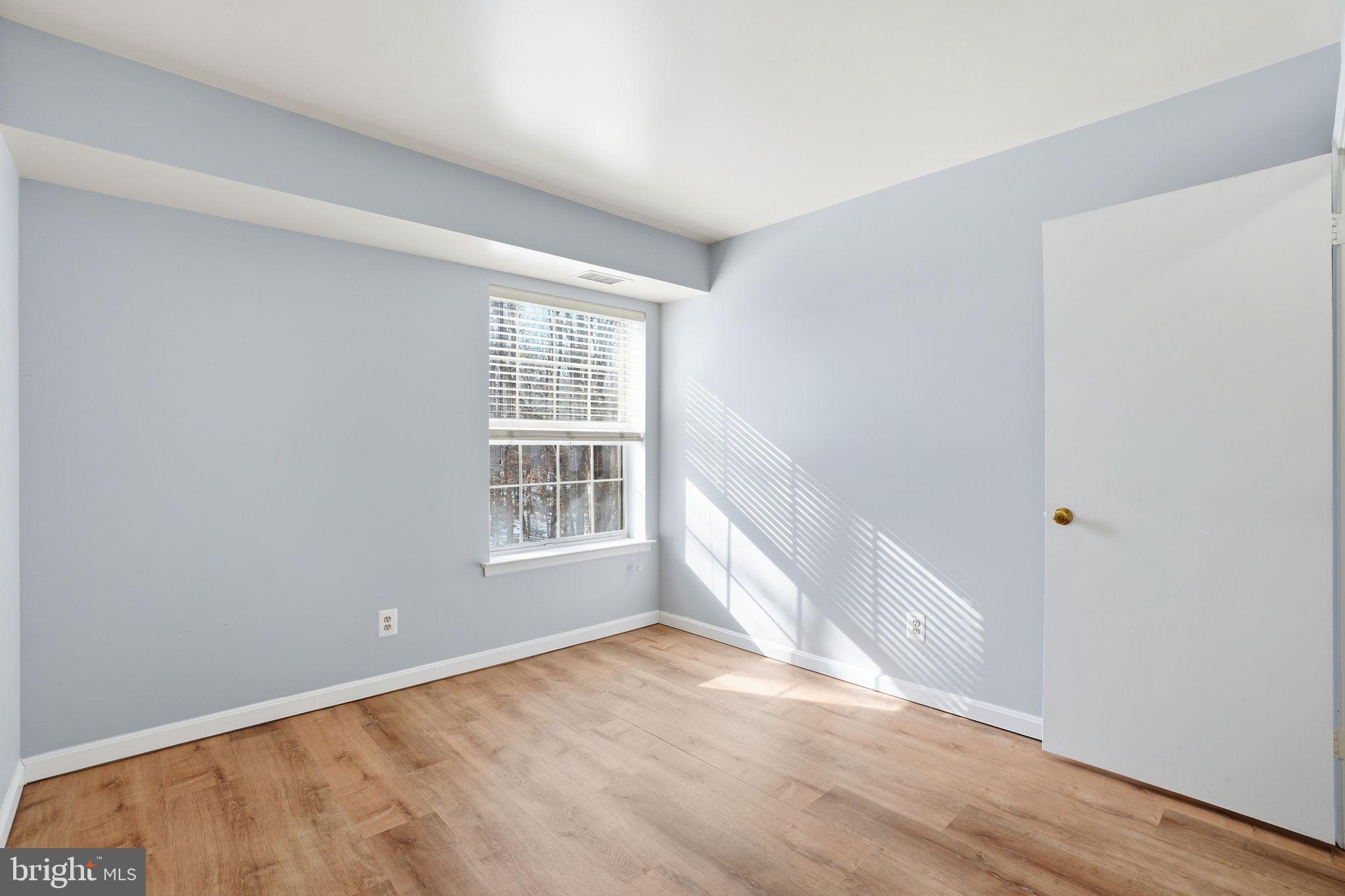 5902 Cove Landing Road, Unit 203 Burke, VA 22015 - Photo 19 of 25 an empty room with wooden floor and windows