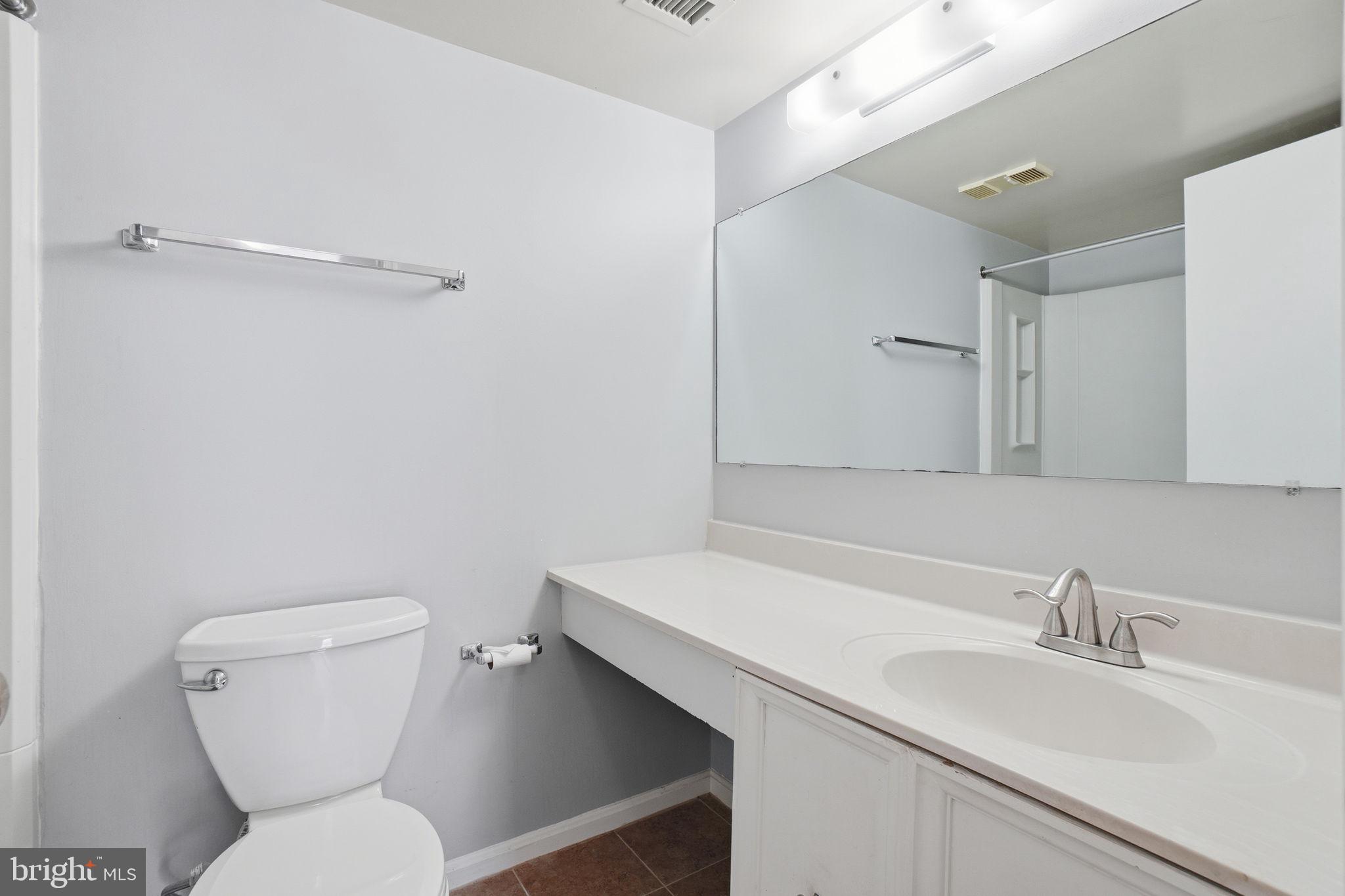 5902 Cove Landing Road, Unit 203 Burke, VA 22015 - Photo 21 of 25 a bathroom with a sink a toilet and a mirror