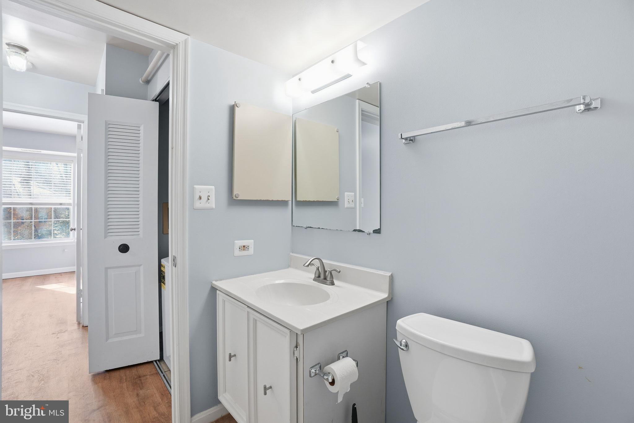 5902 Cove Landing Road, Unit 203 Burke, VA 22015 - Photo 22 of 25 a bathroom with a toilet sink and mirror