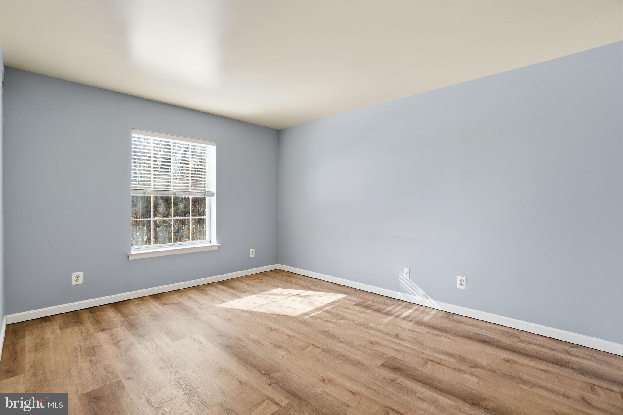 5902 Cove Landing Road, Unit 203 Burke, VA 22015 - Photo 3 of 25 an empty room with wooden floor and windows