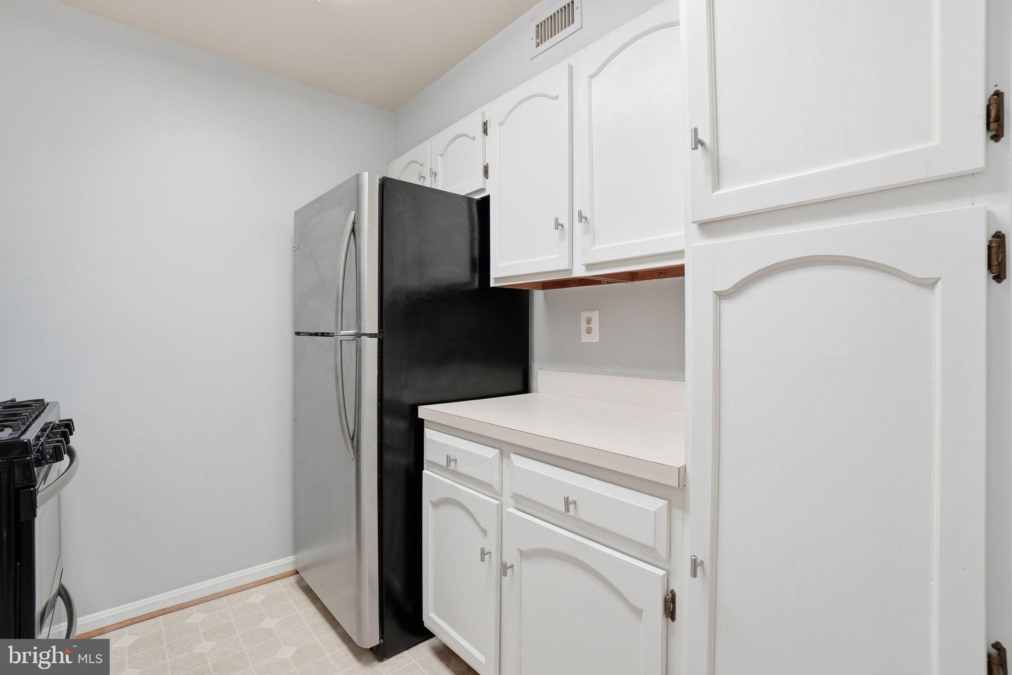 5902 Cove Landing Road, Unit 203 Burke, VA 22015 - Photo 8 of 25 a kitchen with white cabinets and refrigerator