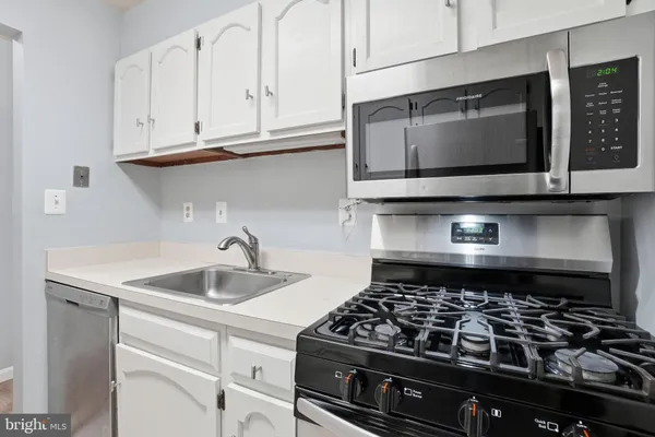 a kitchen with microwave stove and cabinets