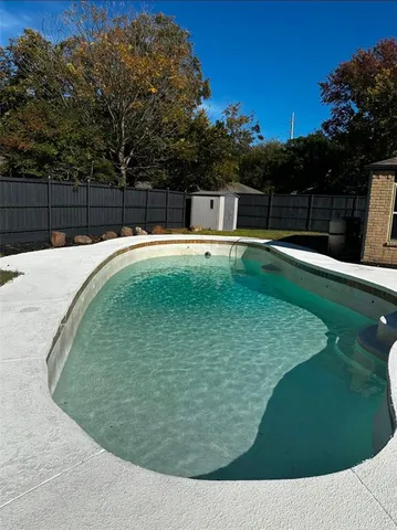 a backyard of a house with a small cabin and wooden fence