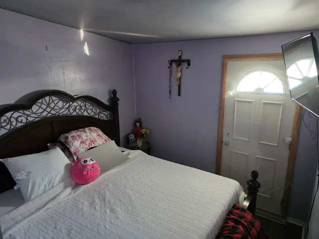 a bedroom with a bed and a painting on the wall