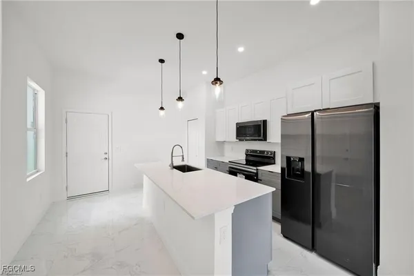 a kitchen with stainless steel appliances a refrigerator sink and stove