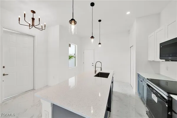 a kitchen with stainless steel appliances granite countertop a sink a stove and a refrigerator