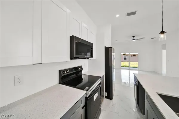 a kitchen with a sink a stove top oven a counter space and cabinets