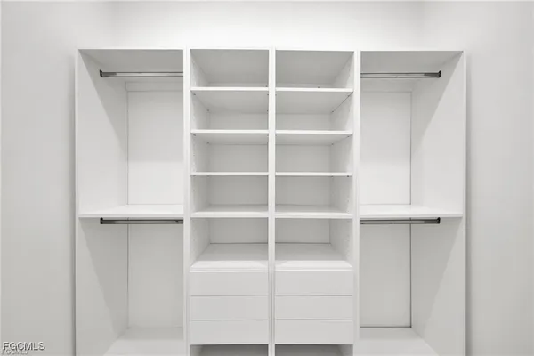 a view of walk in closet with empty racks