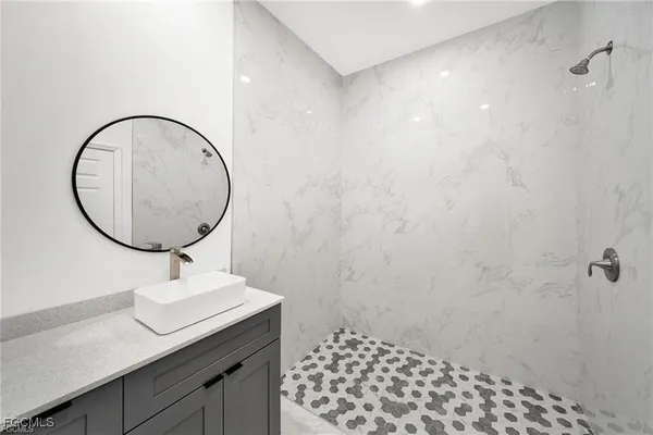 a bathroom with a sink a mirror and a shower