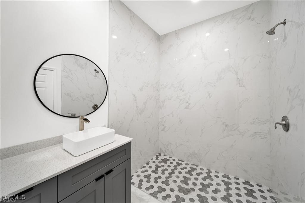 4768 Nelson Drive Lehigh Acres, FL 33973 - Photo 20 of 30 a bathroom with a sink a mirror and a shower
