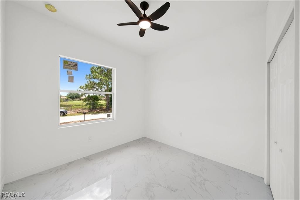 4768 Nelson Drive Lehigh Acres, FL 33973 - Photo 24 of 30 an empty room with windows and fan
