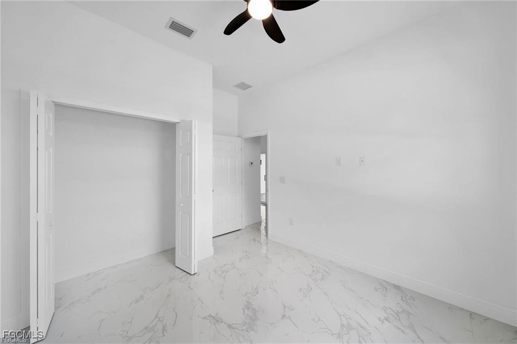 4768 Nelson Drive Lehigh Acres, FL 33973 - Photo 25 of 30 an empty room with ceiling fan and window