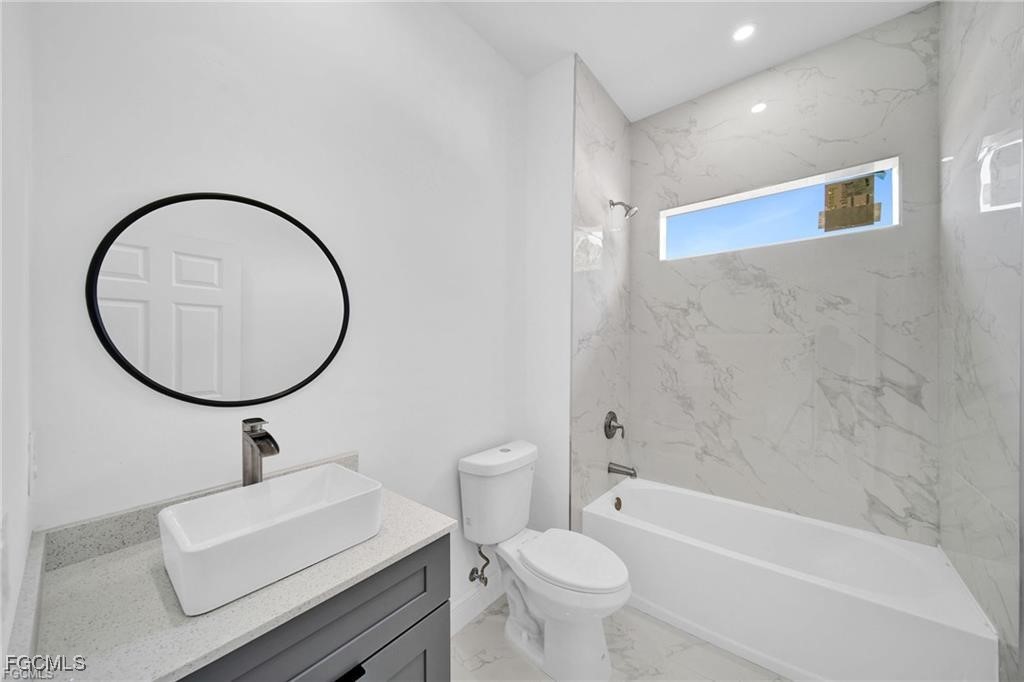 4768 Nelson Drive Lehigh Acres, FL 33973 - Photo 26 of 30 a bathroom with a sink a toilet and a mirror