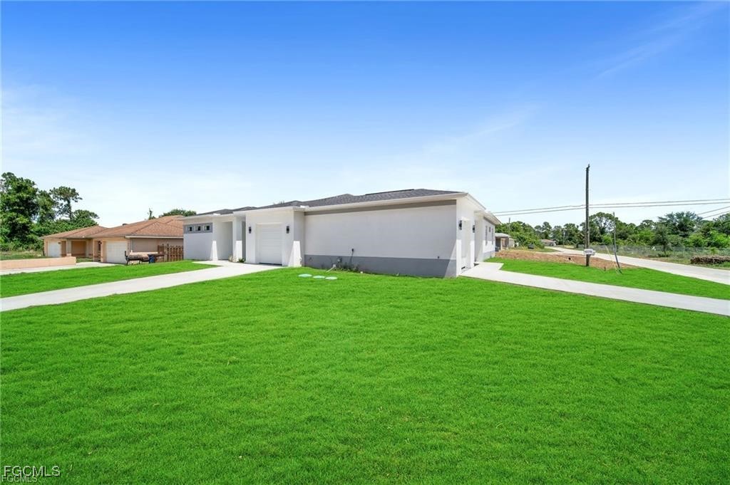 4768 Nelson Drive Lehigh Acres, FL 33973 - Photo 7 of 30 a view of a house with a yard and a large tree