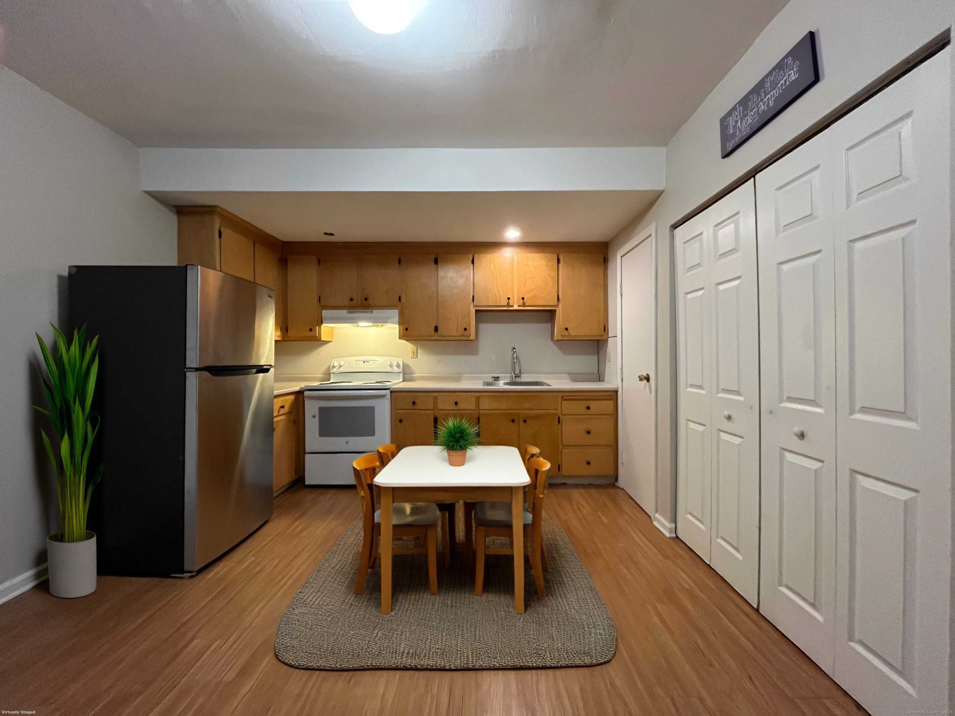 19 Divinity Street, Unit 3E Bristol, CT 06010 - Photo 5 of 16 a kitchen with stainless steel appliances granite countertop a refrigerator a sink a stove and white cabinets with wooden floor