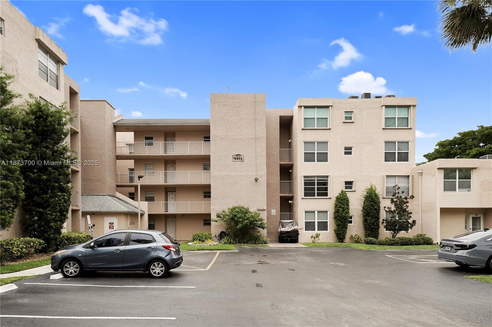 9491 Evergreen Place, Unit 207 Davie, FL 33324 - Photo 1 of 42 a front view of a building with cars parked on the roadside