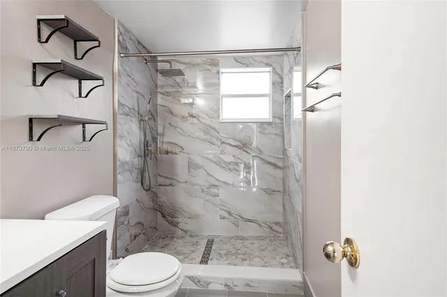 a white toilet sitting next to a bathroom sink