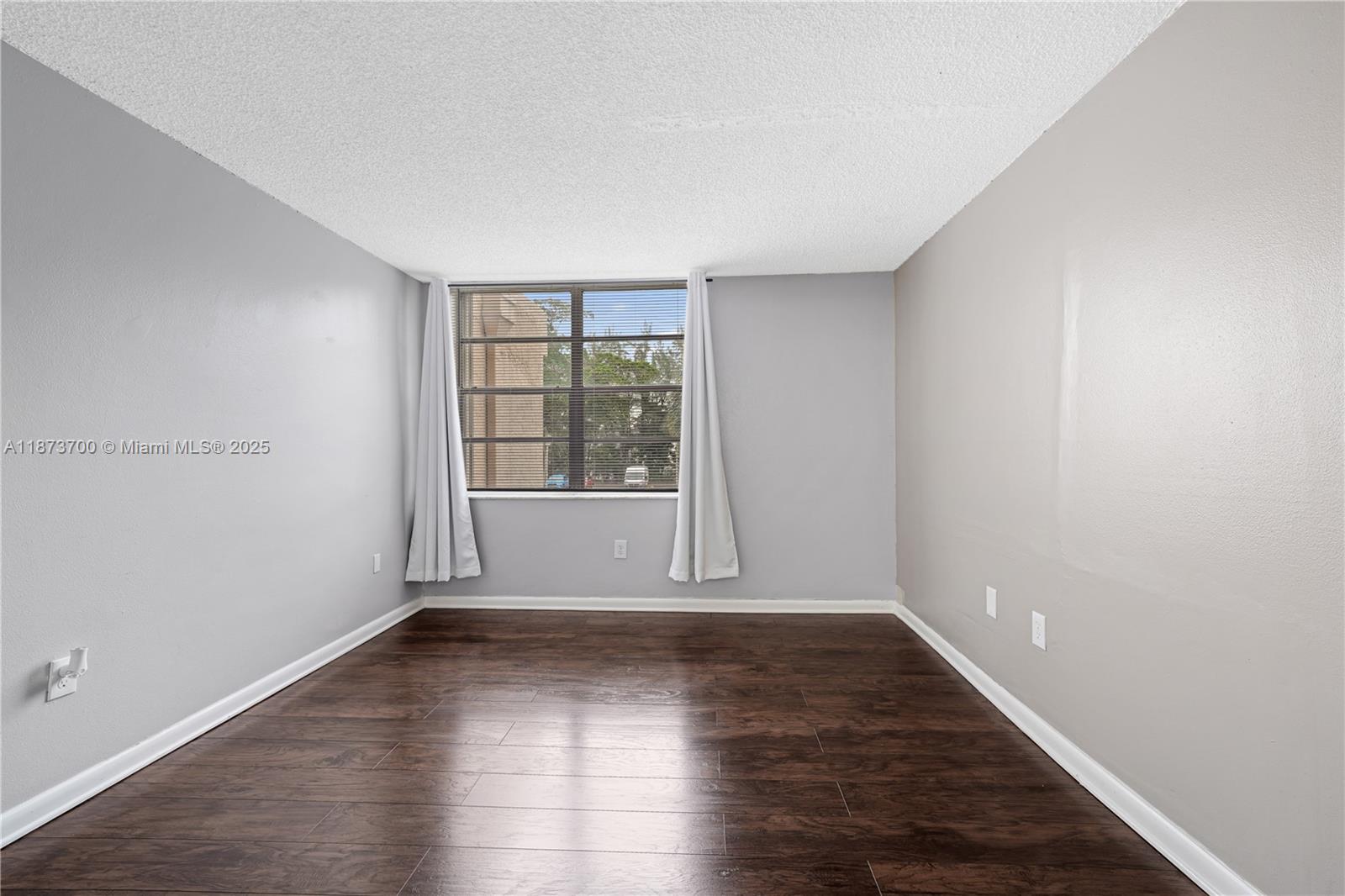 9491 Evergreen Place, Unit 207 Davie, FL 33324 - Photo 19 of 42 wooden floor in an empty room with a window