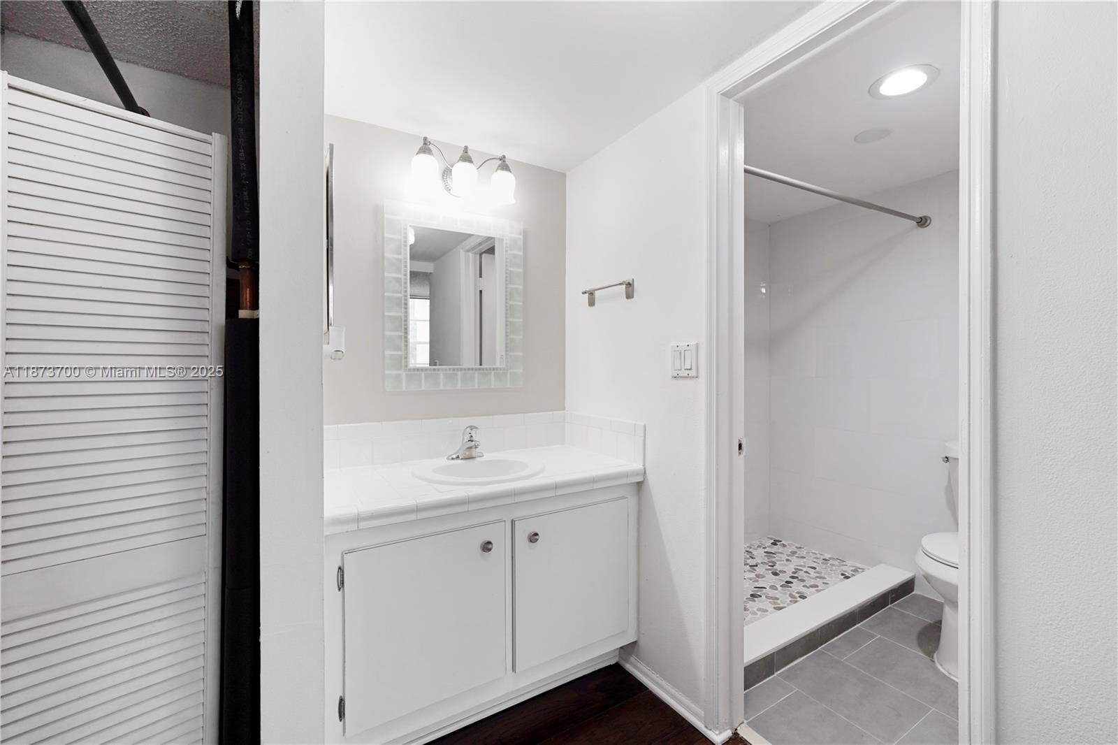 9491 Evergreen Place, Unit 207 Davie, FL 33324 - Photo 20 of 42 a bathroom with a sink a mirror and a shower