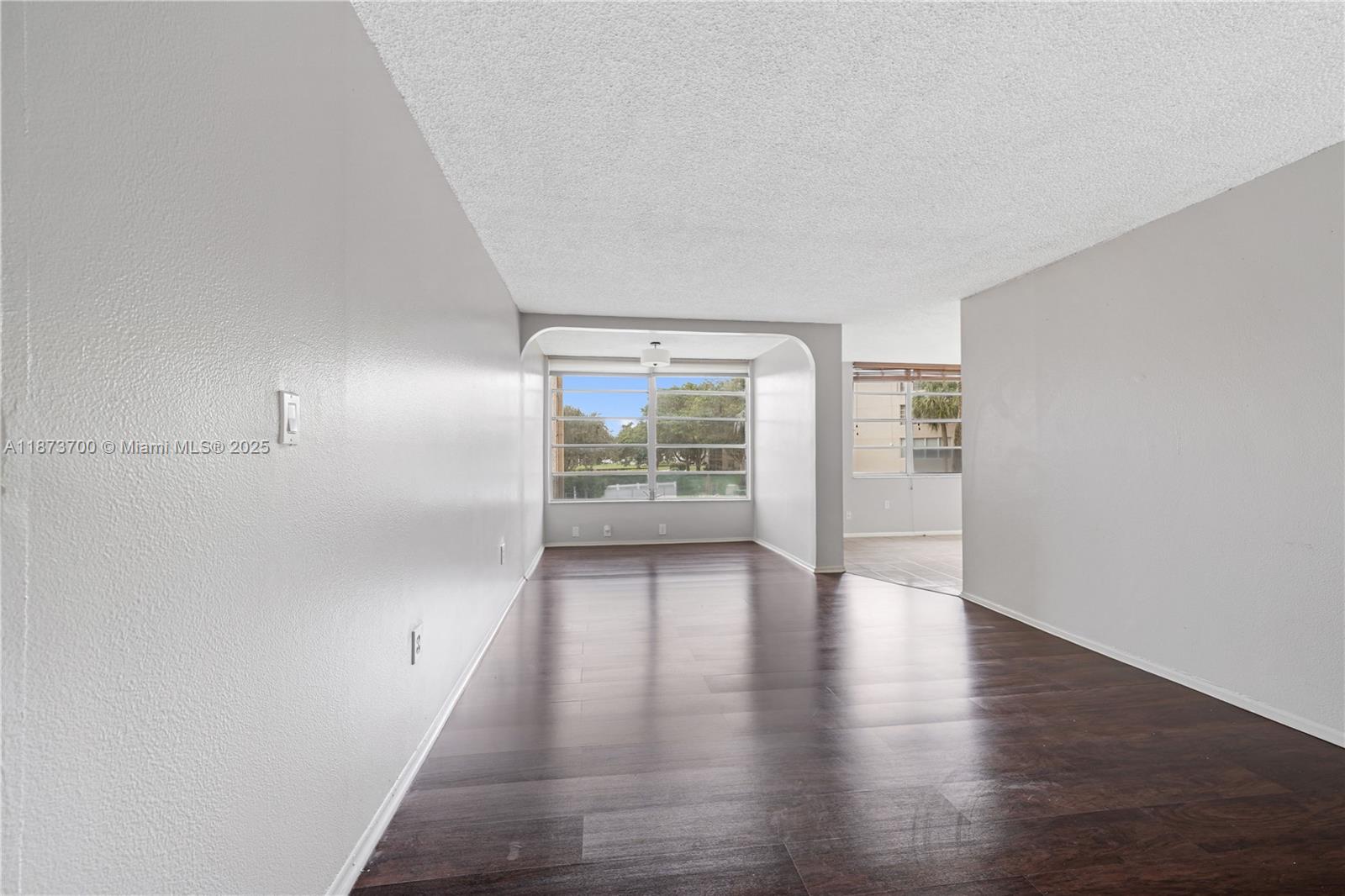 9491 Evergreen Place, Unit 207 Davie, FL 33324 - Photo 2 of 42 wooden floor in an empty room with a window