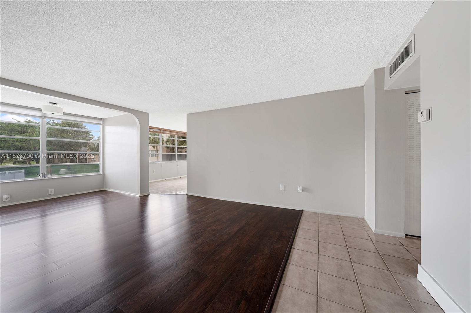 9491 Evergreen Place, Unit 207 Davie, FL 33324 - Photo 3 of 42 an empty room with wooden floor and windows