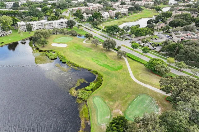 an aerial view of residential houses with outdoor space and lakeside