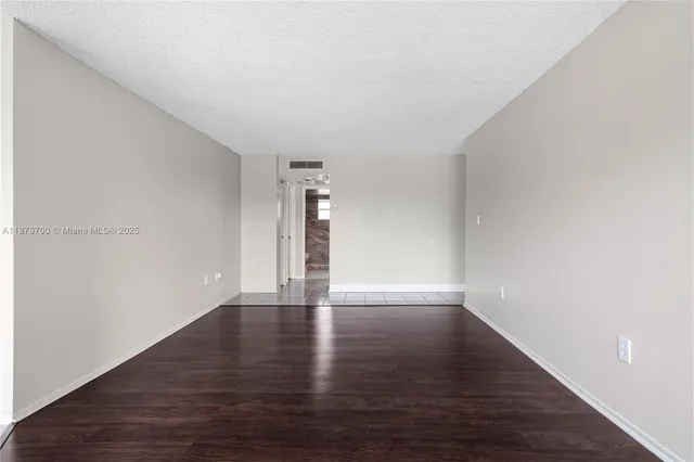 a view of an empty room and wooden floor