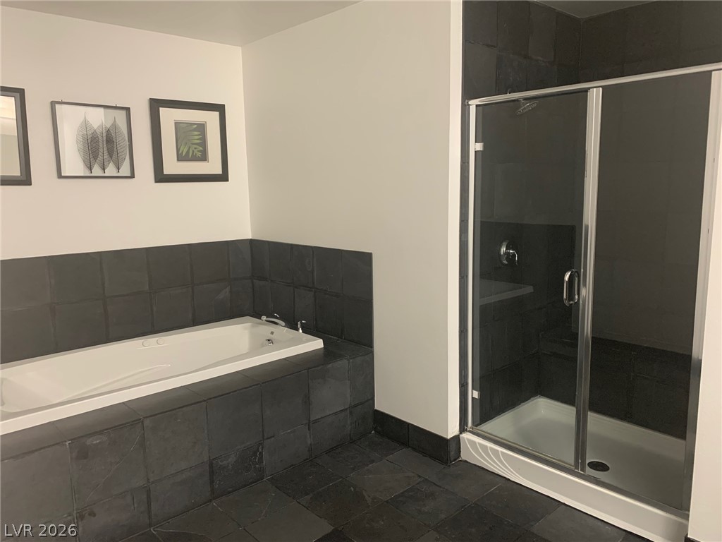 2775 West Pebble Road, Unit 325 Las Vegas, NV 89123 - Photo 4 of 7 An inviting bathroom offers a deep soaking tub and a sleek glass-enclosed shower.