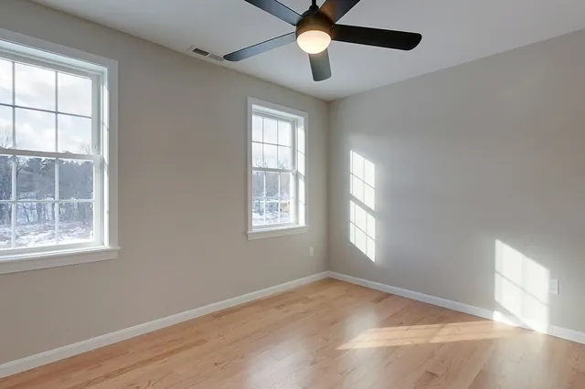 an empty room with wooden floor a ceiling fan and closet
