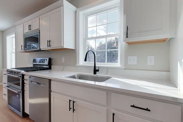 a kitchen with stainless steel appliances granite countertop a sink and a microwave