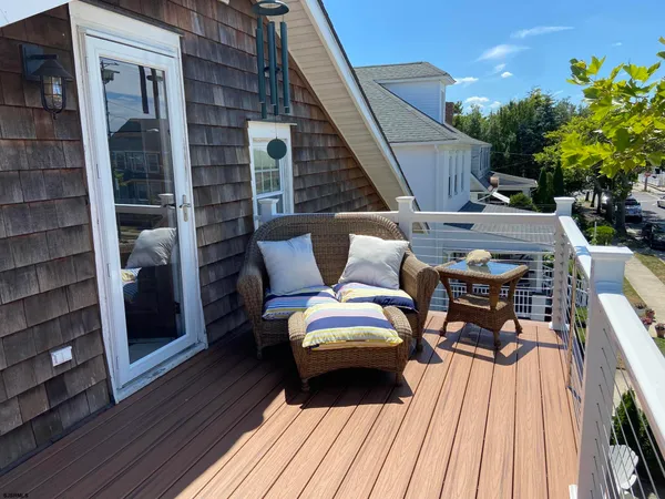 a view of a balcony with wooden floor and iron fence