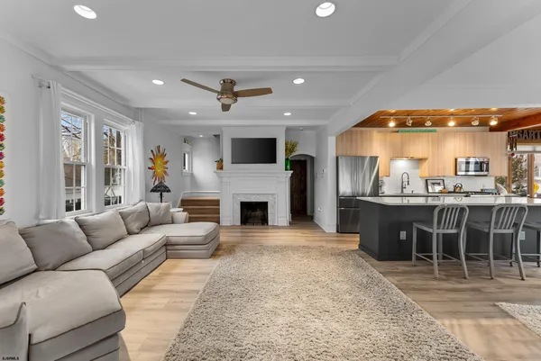 a living room with furniture a fireplace and a kitchen view