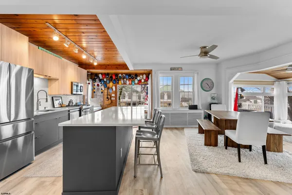 a living room with furniture a table and kitchen view
