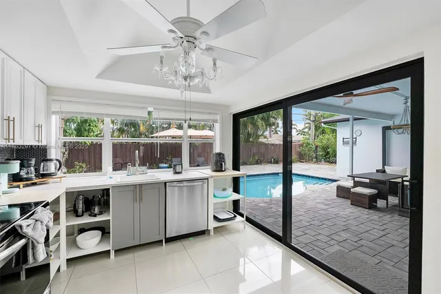 a view of a kitchen with kitchen island a large window cabinets and stainless steel appliances