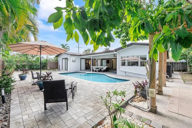 a view of a house with backyard and sitting area