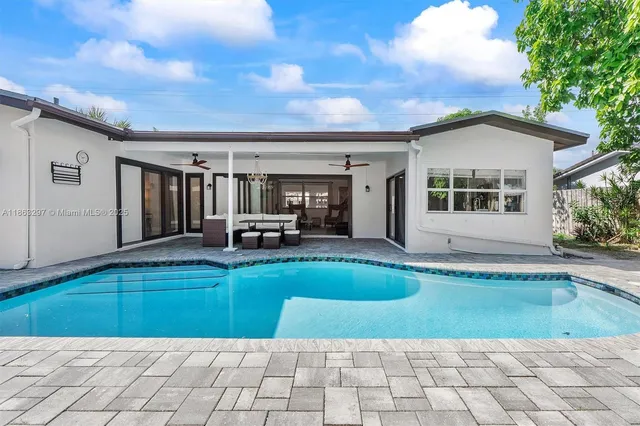a view of a house with backyard and swimming pool