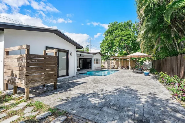a backyard of a house with barbeque oven and outdoor seating
