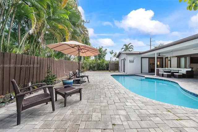 a view of a patio with chairs and a table under an umbrella