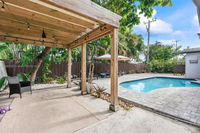 a view of a patio with table and chairs potted plants with wooden floor and fence