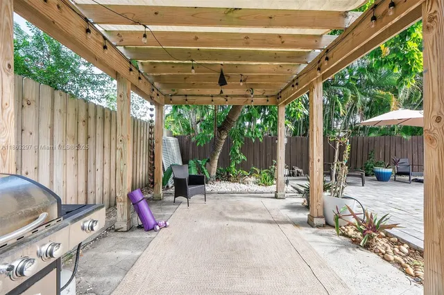 a view of a patio with table and chairs and wooden fence with plants