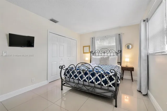 a bedroom with a bed chair and a window