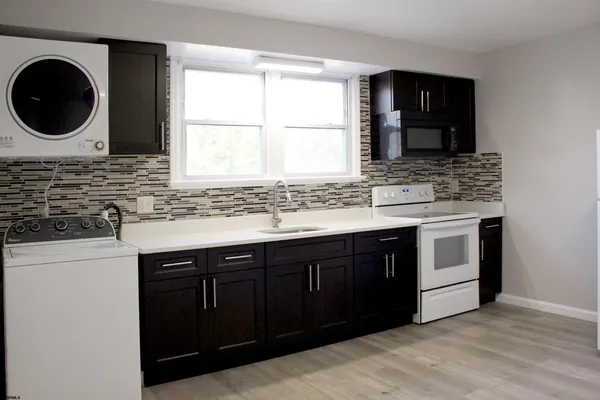 a kitchen with a stove a sink and a window