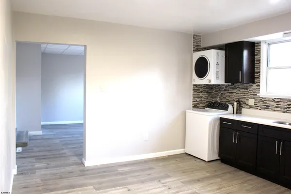 a view of kitchen with wooden floor and cabinets