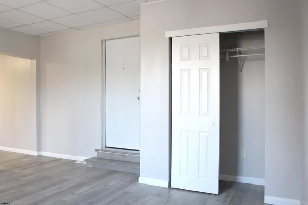 an empty room with wooden floor and closet